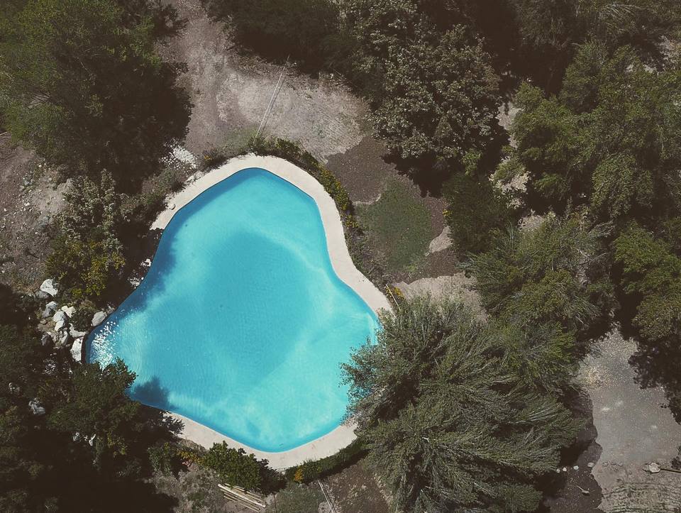 Vista aérea vertical de la piscina en forma irregular de Camping La Isla
